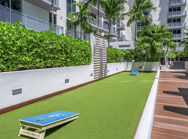 A blue frisbee is on a green artificial lawn.